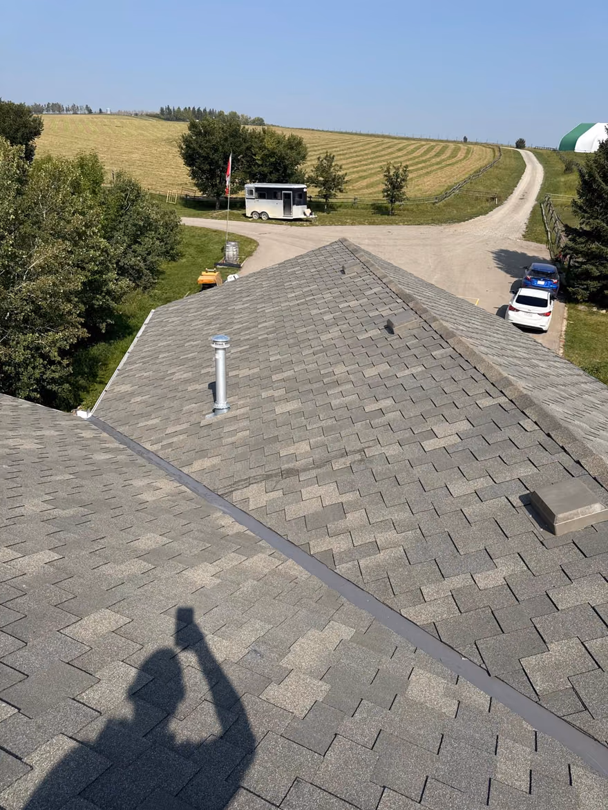 Aerial view aging shingle roof with plumbing stack