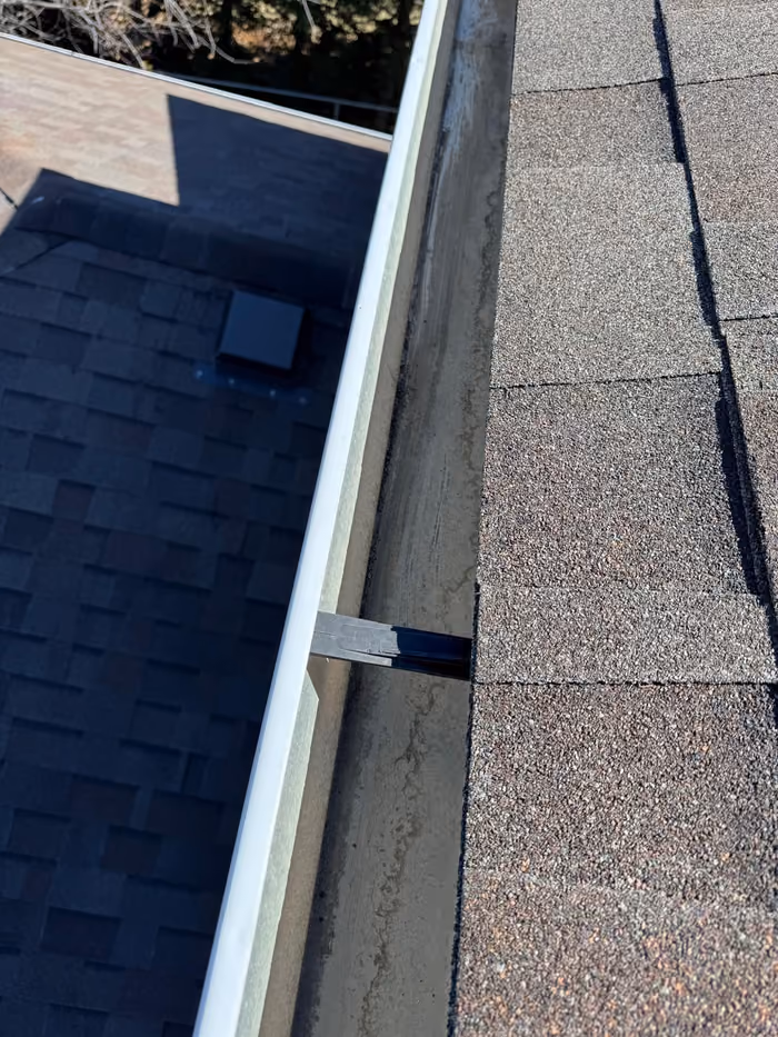 Close up eavestrough hanger and shingle edge detail