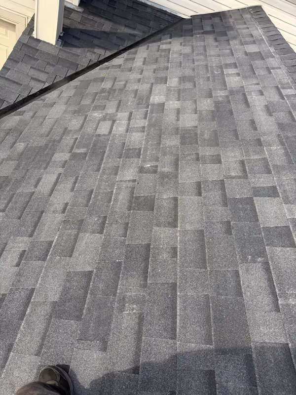 Close up new asphalt shingle courses against siding