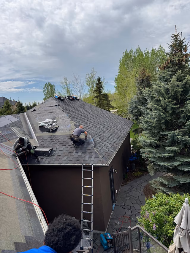 Crew member on roof with ladder access set up