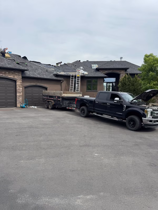Dump trailer and truck parked at roofing jobsite
