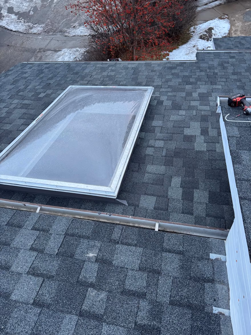Finished glass skylight flashed into shingle roof