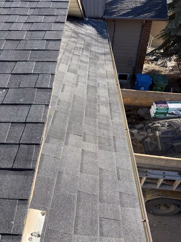 Finished shingles beside open eave framing mid job