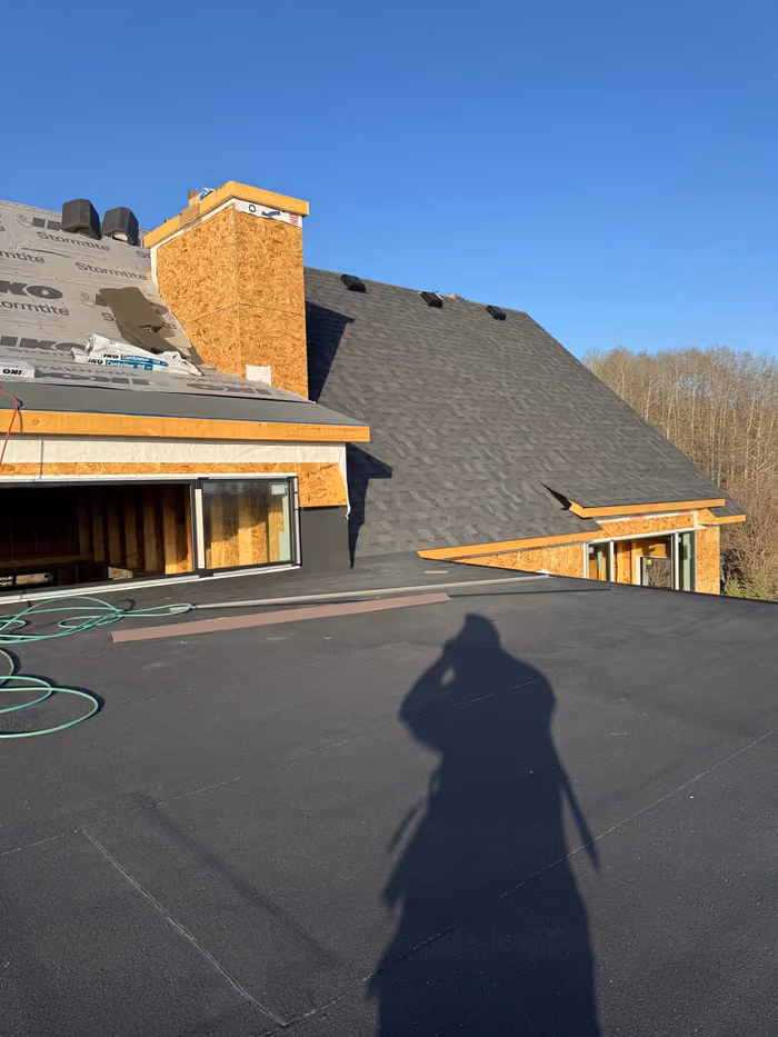 Low slope membrane roof with shingled gable beyond