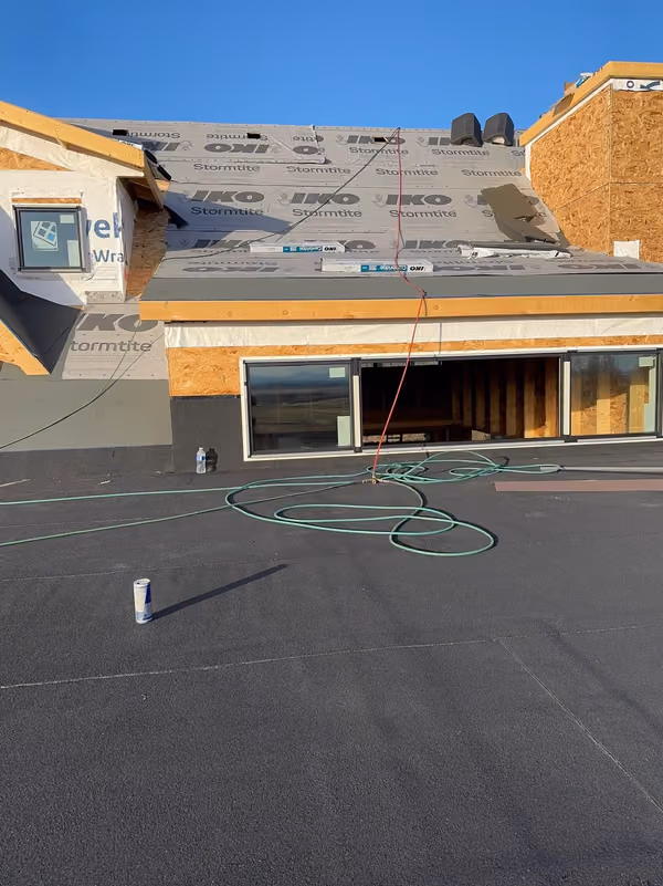 Membrane deck with house wrap and shingled slope behind