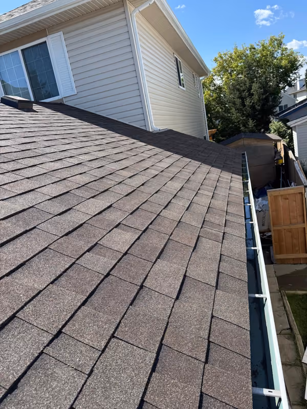 New shingles with eavestrough along roof edge