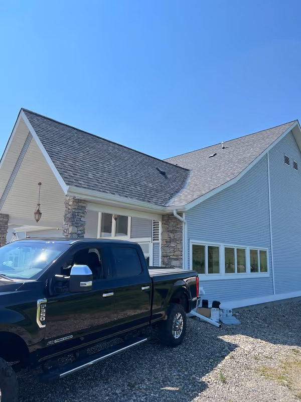 Pickup truck parked at home with finished shingle roof