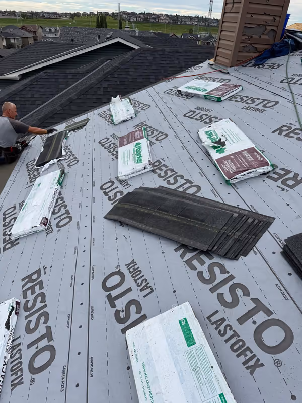 Roofer installing starter course over underlayment