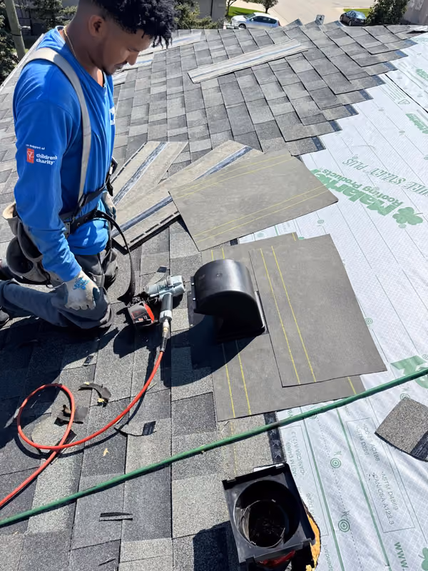 Roofer nailing roof vent onto underlayment