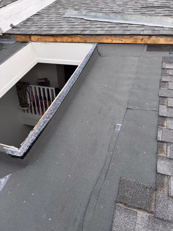 Skylight curb membrane flashed with opening into room