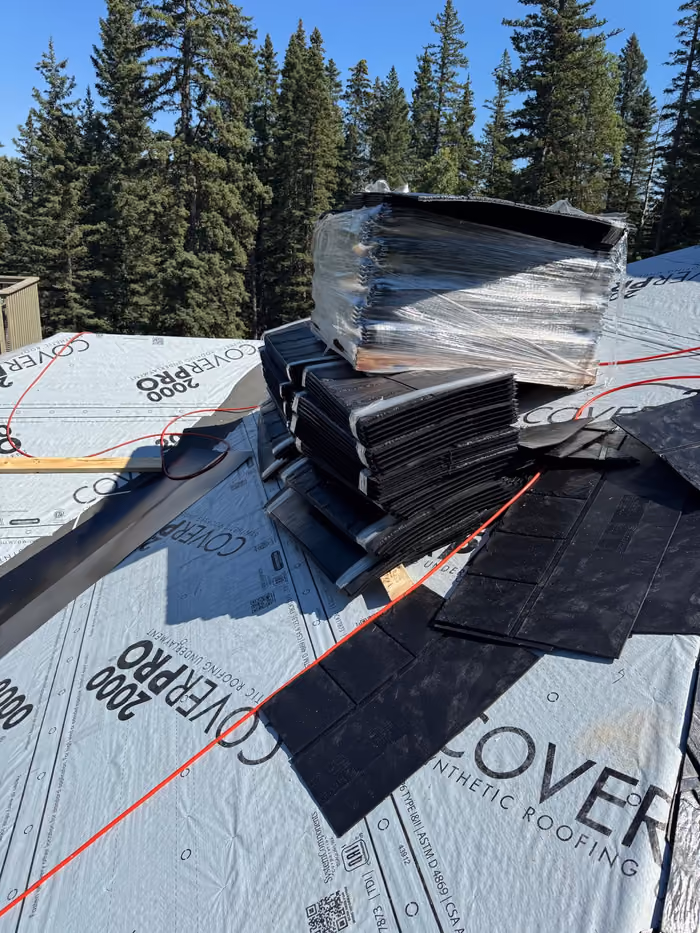Synthetic slate bundles and underlayment on roof deck