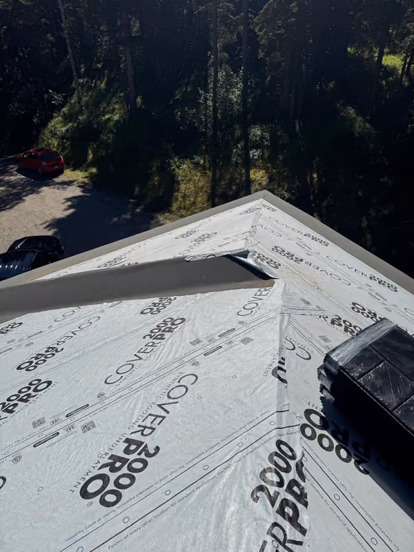 Synthetic underlayment covering hip roof deck