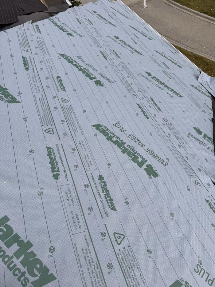 Synthetic underlayment fully covering stripped roof slope
