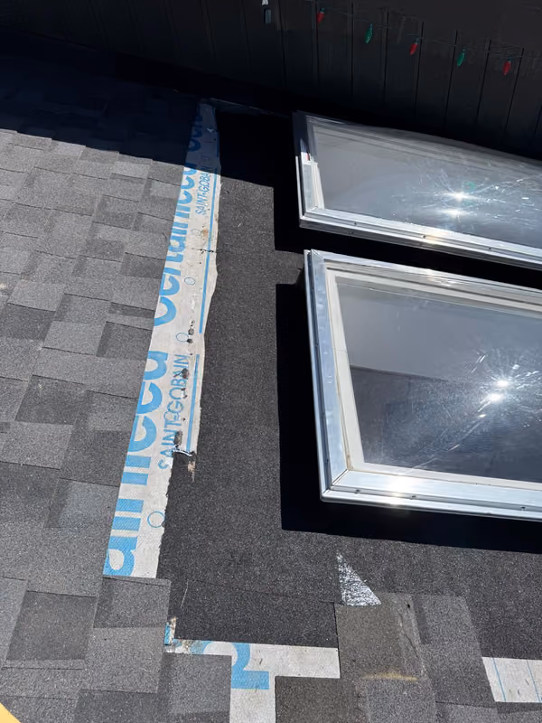 Two skylights installed side by side on shingle roof