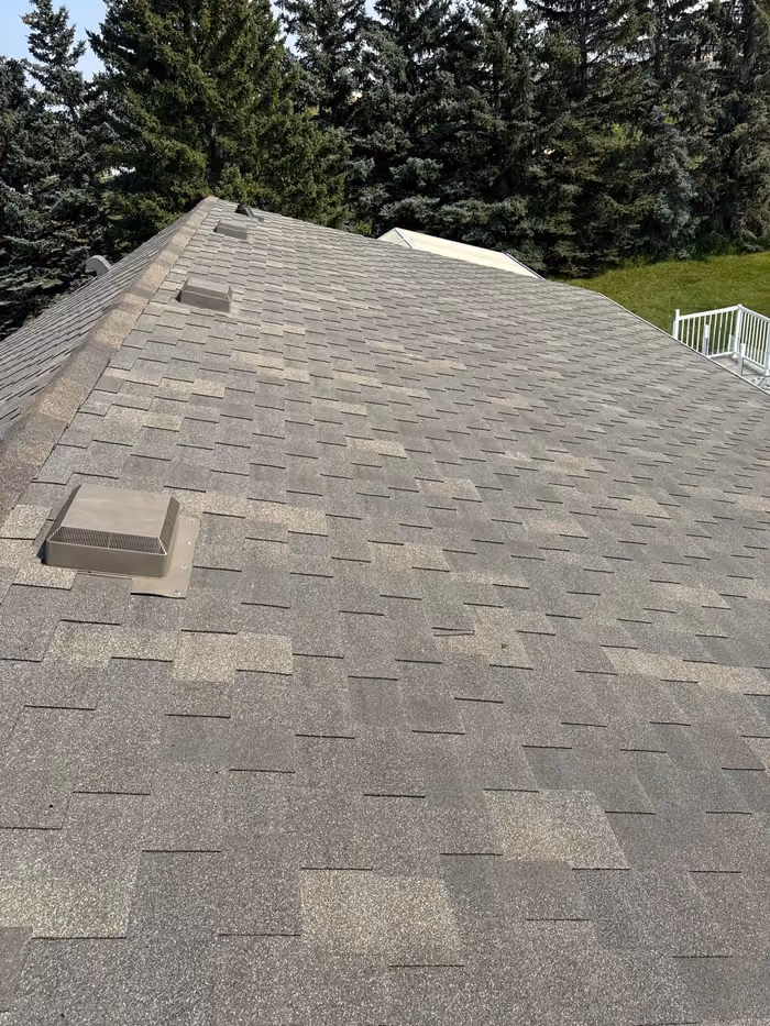 Worn asphalt shingle slope with box vent close up